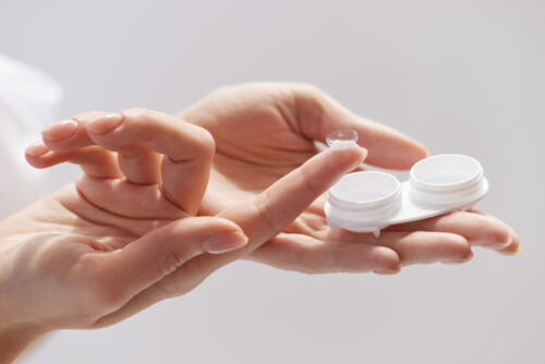 Contact Eye Lenses. Woman using proper care while inserting her contact lens.