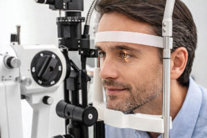 Man undergoing a comprehensive eye exam for a myopia diagnosis, to get the right treatment at M&M Eye Institute.