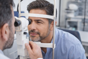 Man recieving a comprehensive eye exam to determine the best farsightedness treatment at M&M Eye Institute