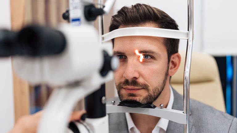 Closer image of a man having a routine comprehensive eye exam.